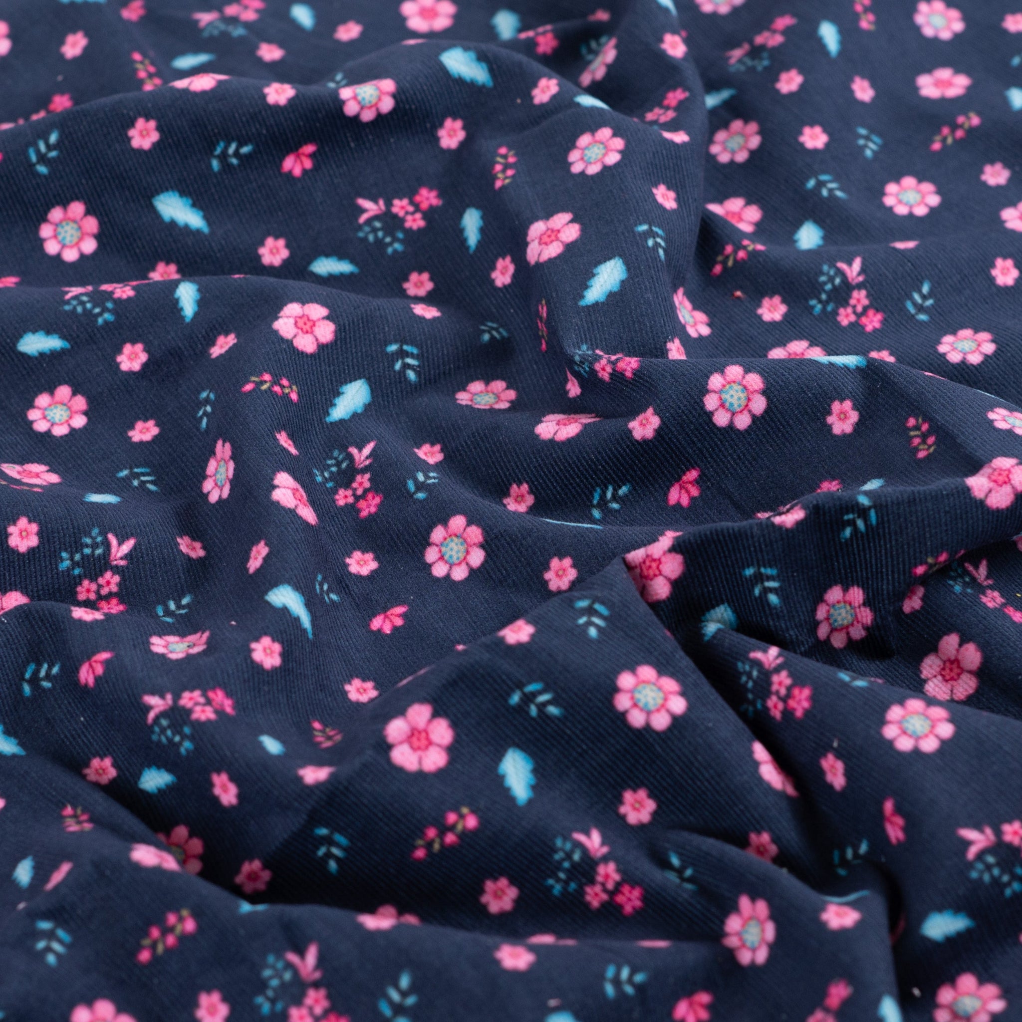 Feincord mit pinken Büten und türkisen Federn auf dunkelblauem Hintergrund vom Buntspecht Shop