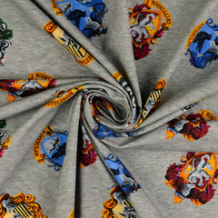 Reststück: 1,00m Baumwolljersey Lizenz -Star Wars Wappen der 4 Hogwarts Häuser - hellgrau